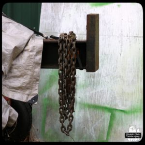 rusty heavy chain hung over a piece of machinery