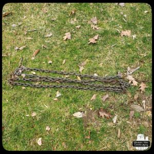 rusty heavy chain laid out in zig-zag on the grass