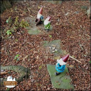 all three gnomes standing on slate stones in Gnome Grove: Sherlock Gnomes, Gnome Chomsky, and Gnomez Addams