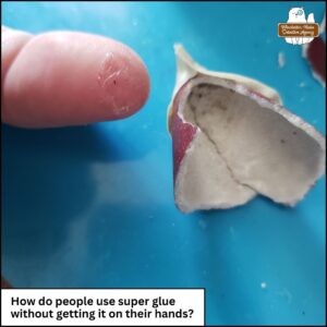 a fingertip with glue on it next to the garden gnome hat being repaired. "How do people use super glue without getting it on their hands?"